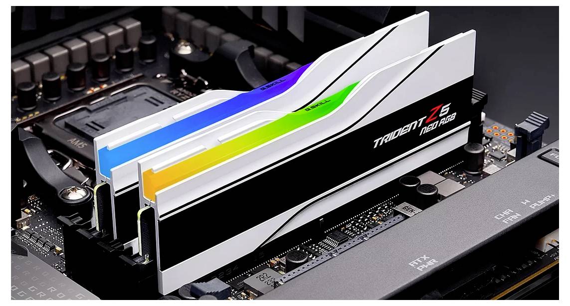 Nahaufnahme von zwei RAM-Modulen auf einem Motherboard, beleuchtet mit bunten LEDs. Die Module tragen die Aufschrift 'Trident Z5 RGB'.