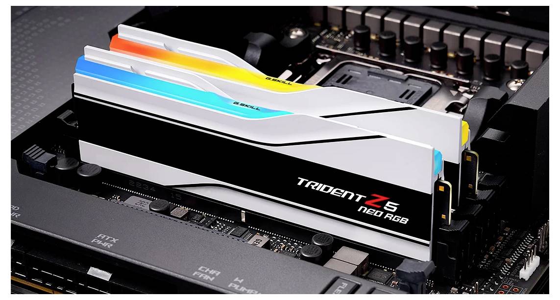 Zwei RAM-Module mit RGB-Beleuchtung in einem Computer-Motherboard installiert, Markenname 'Trident Z5 Neo RGB' sichtbar.