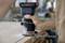 Eine Person nutzt einen Bosch-Elektrofräse an einer Holzkante, um präzise Arbeiten durchzuführen. Im Hintergrund unscharfe Werkstattumgebung.