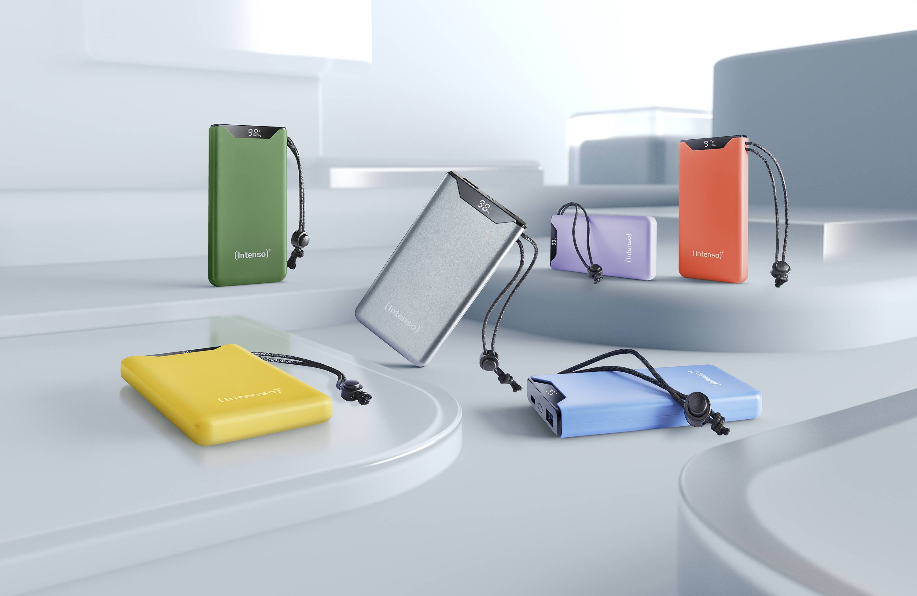 Verschiedene farbige Powerbanks mit Schlüsselbändern liegen auf gestuften, grauen Oberflächen. Markenname 'Leamonat' sichtbar.