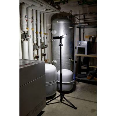 Ein beleuchteter Heizungsraum mit einem Wassertank, Rohren und einem Stativ mit Licht in der Mitte.