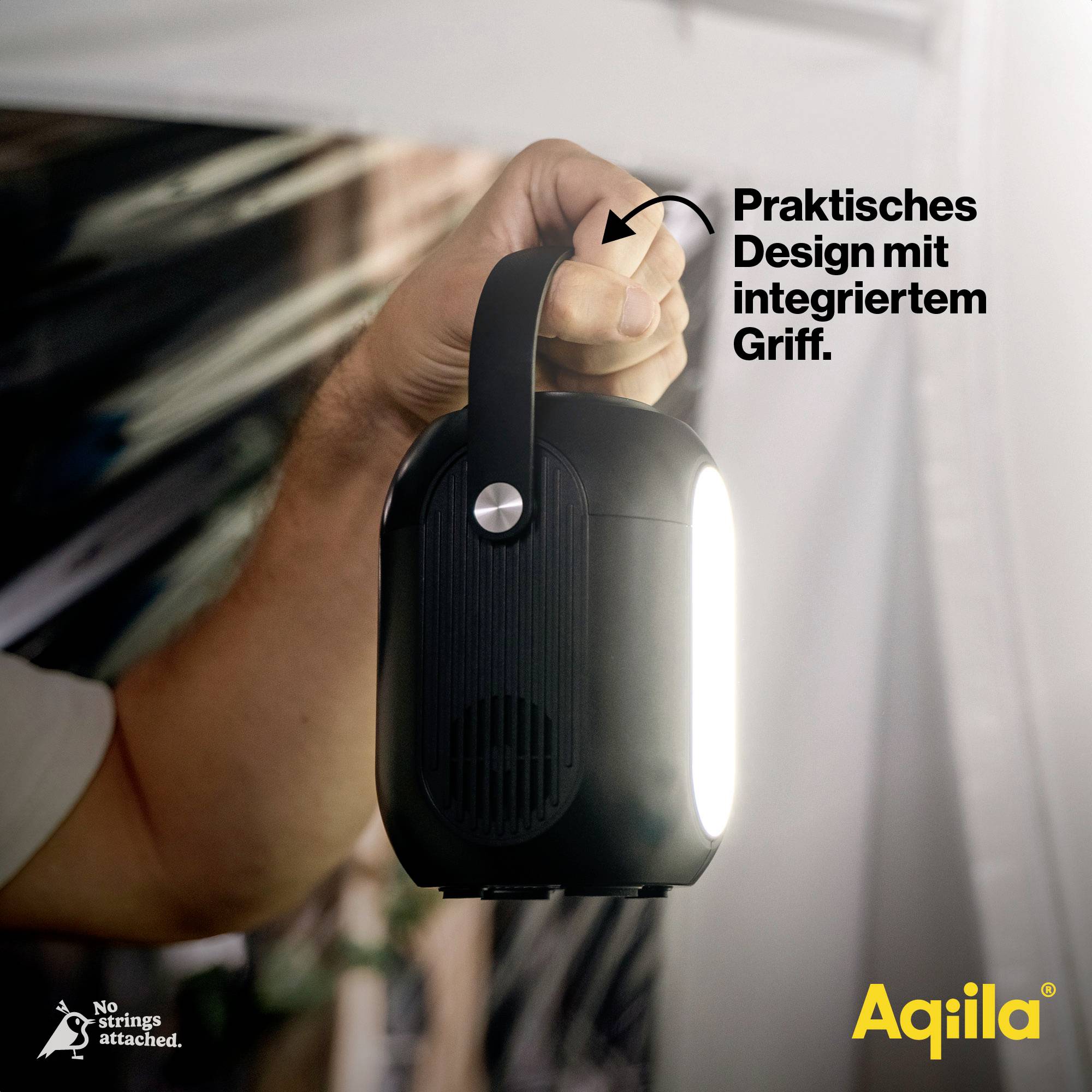 Ein Arm hält eine schwarze Lampe mit einem integrierten Griff. Der Text 'Praktisches Design mit integriertem Griff' erklärt das Produktmerkmal. Links unten Logo 'No Strings attached', rechts unten 'Aqila'.