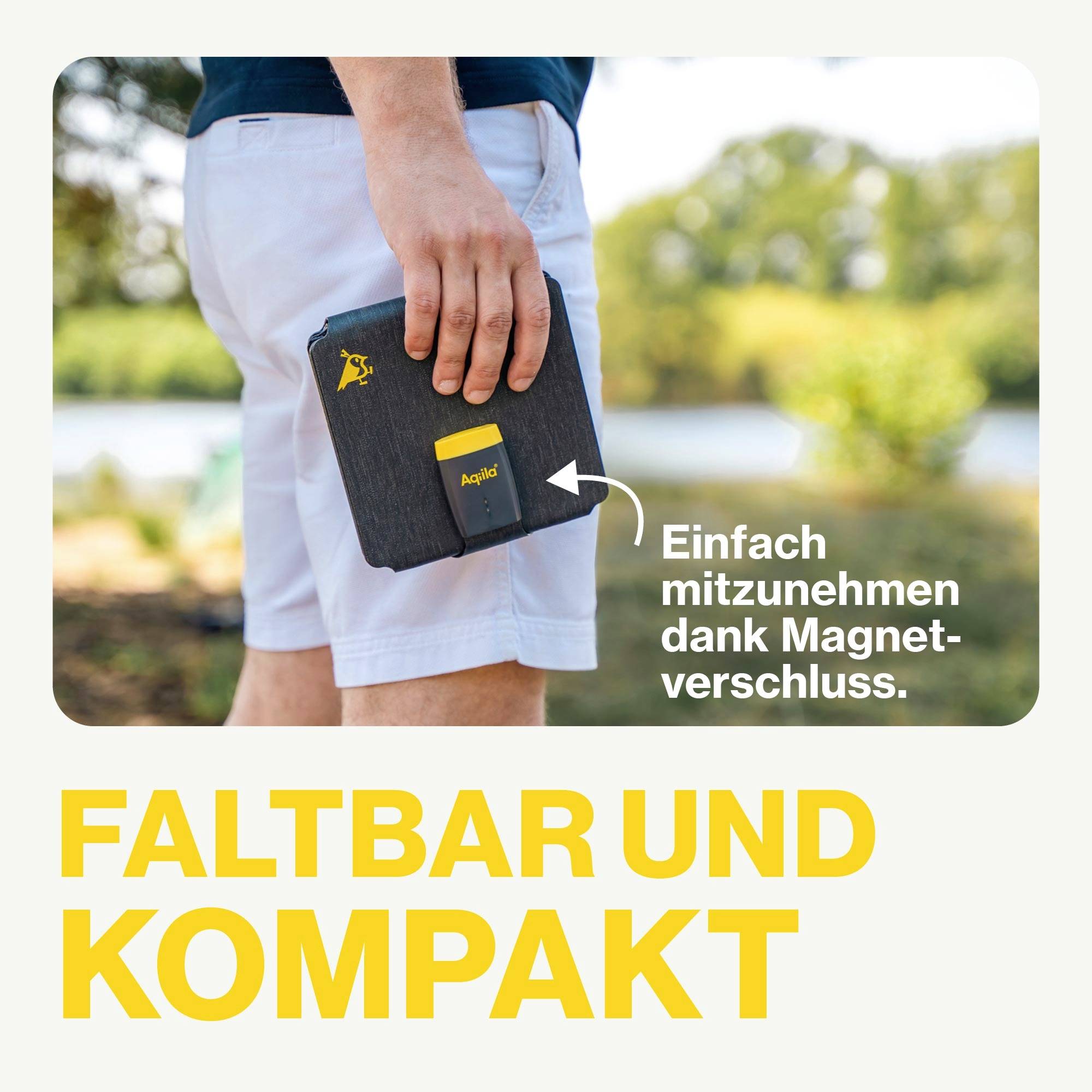 Person hält eine zusammenklappbare, magnetverschlossene Tasche mit Illustration einer Ente und Schriftzug 'Einfach mitzunehmen dank Magnetverschluss'. Hintergrund: Natur. Text: 'Faltbar und kompakt'.