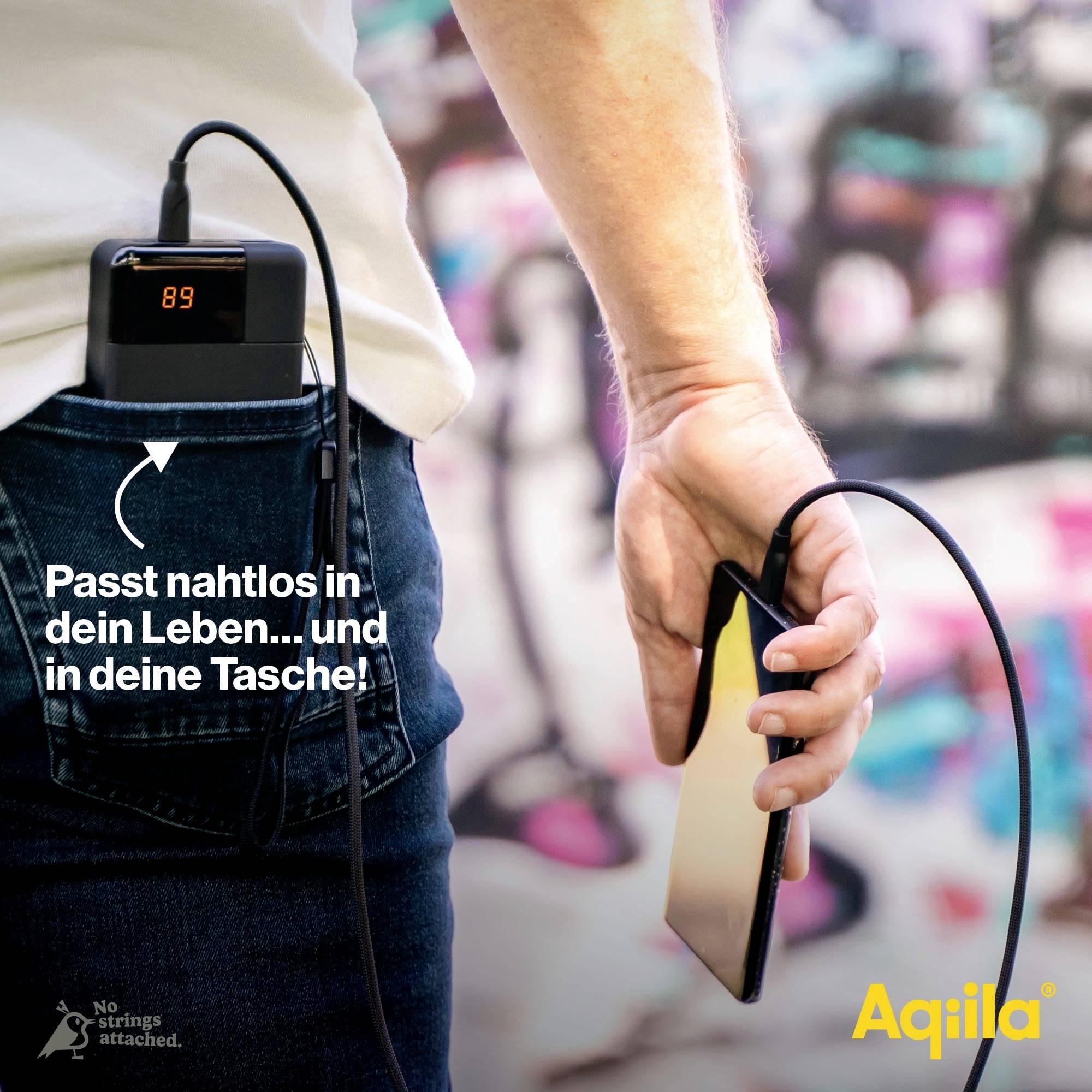 Ein Smartphone wird von einer Hand gehalten, mit einem Akkupack, das bei 89% ist und aus einer Tasche ragt. Text: 'Passt nahtlos... in dein Leben und in deine Tasche!'. Markenname: Aqila.