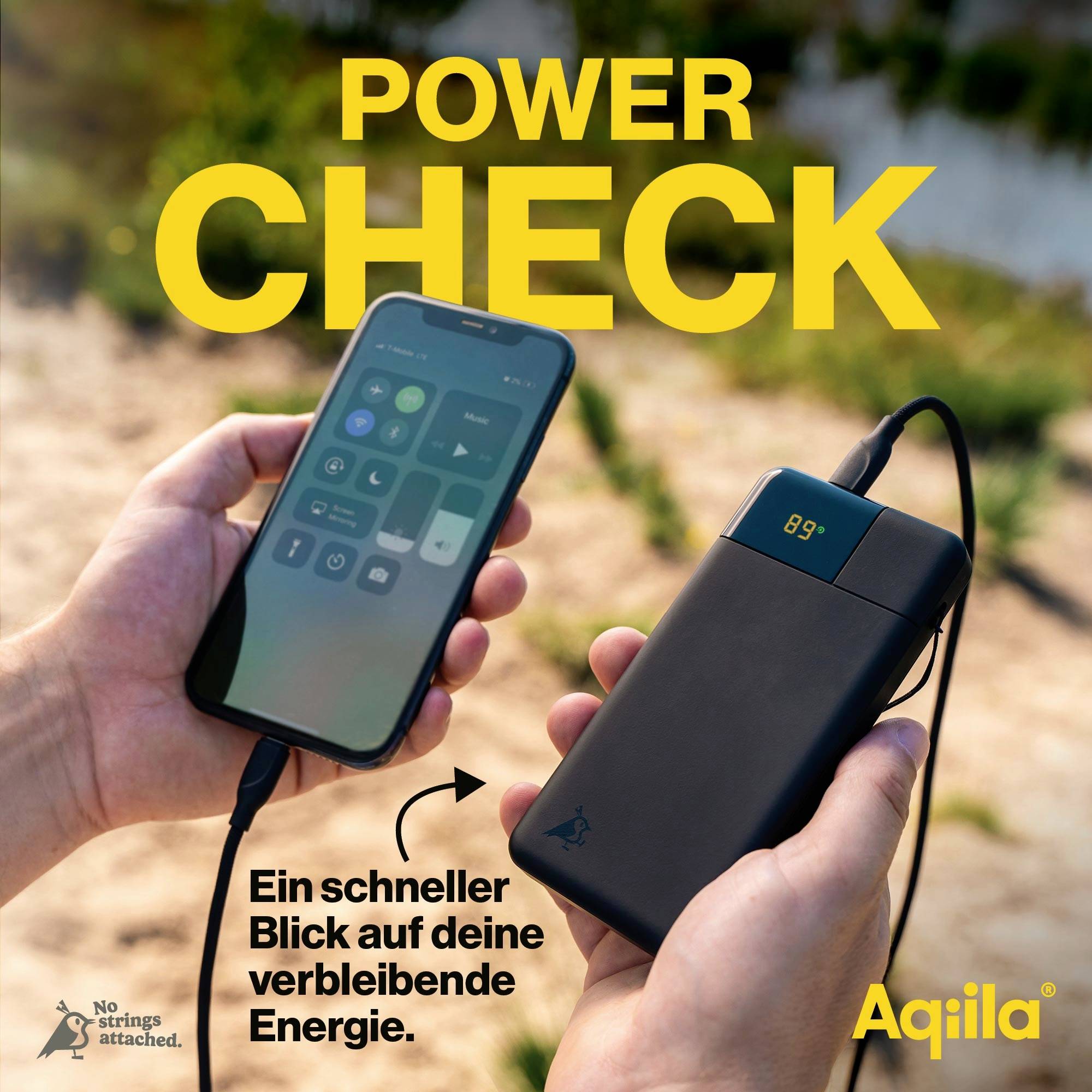 Zwei Hände halten ein Smartphone und eine Powerbank mit Ladeanzeige. Text: 'POWER CHECK'. Hintergrund unscharf; Fokus auf Geräten.