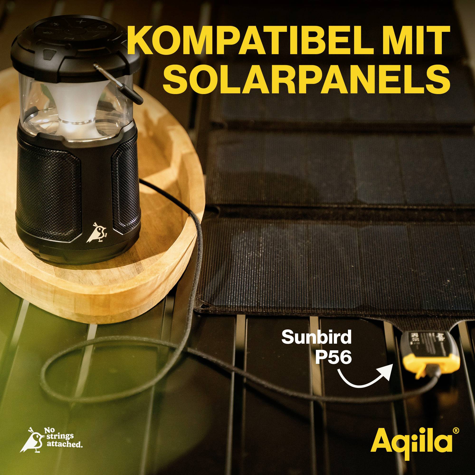 Laterne mit Solarpanel kompatibel, auf Tisch mit Kabel verbunden. Text 'KOMPATIBEL MIT SOLARPANELS' und Logo 'Aqilla'.