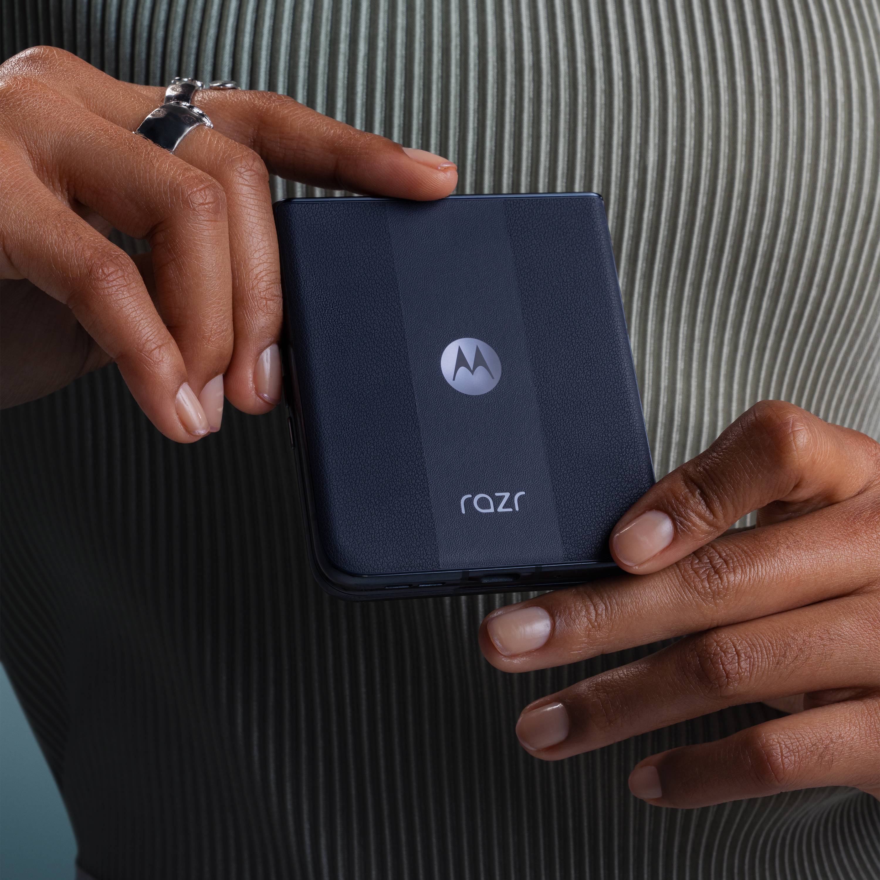 Person hält ein gefaltetes Smartphone mit Motorola-Logo in der Hand. Das Design ist kompakt und modern, symbolisiert innovative Technologie.