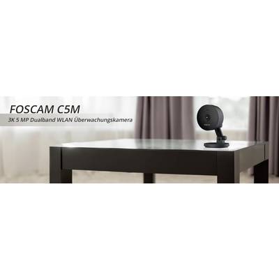 Überwachungskamera auf einem Tisch. Text: 'FOSCAM C5M - 3K 5 MP Dualband WLAN Überwachungskamera'.