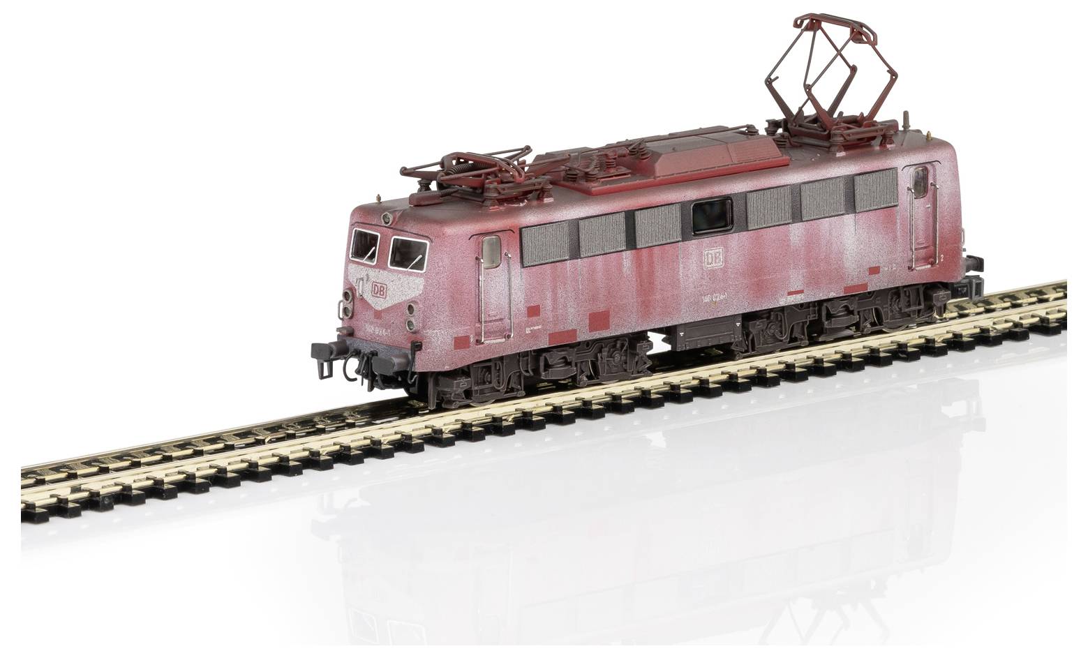 Ein rotes Modellzug-Lokomotive fährt auf einem Gleis. Die Lokomotive hat eine abgenutzte Optik und detaillierte Komponenten oben.