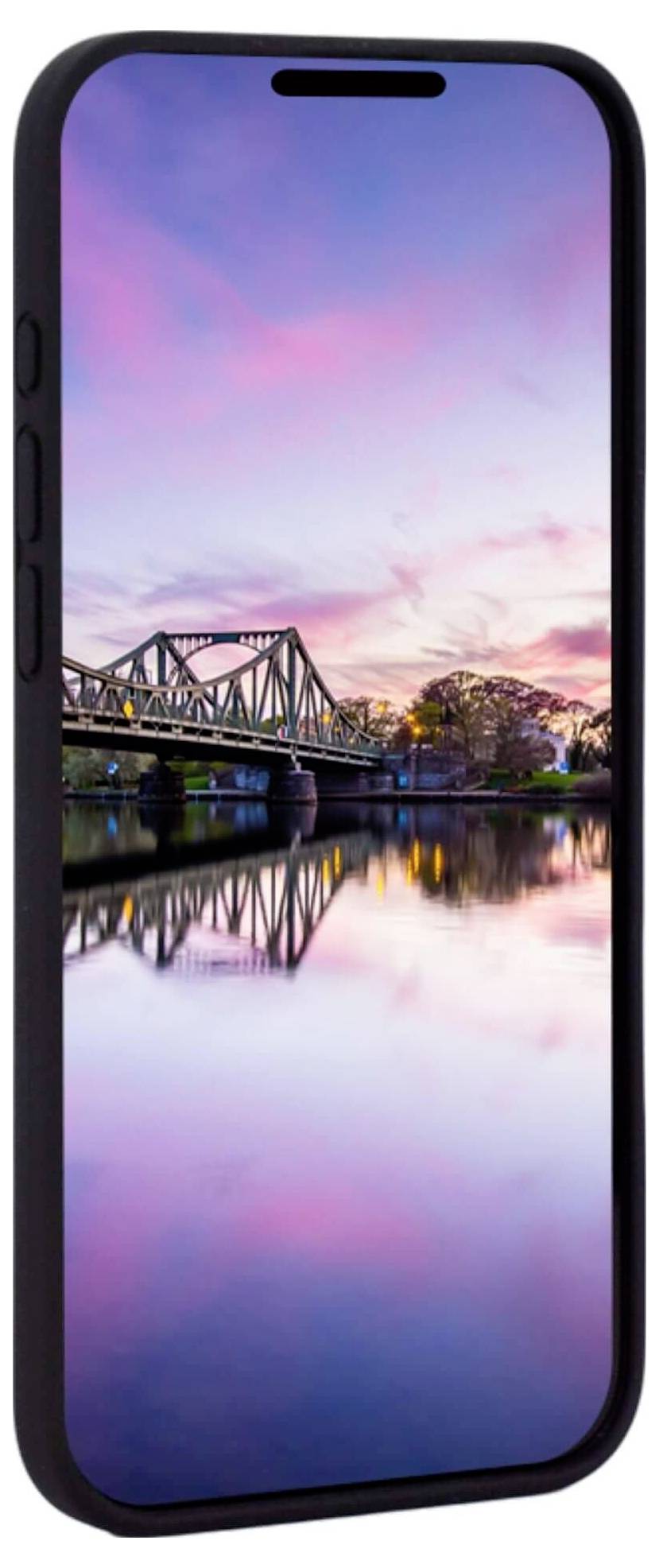 Ein Smartphone mit einer bunten Bildschirmhintergrundanzeige eines beleuchteten Brückenpanoramas bei Sonnenuntergang über einem ruhigen Fluss.