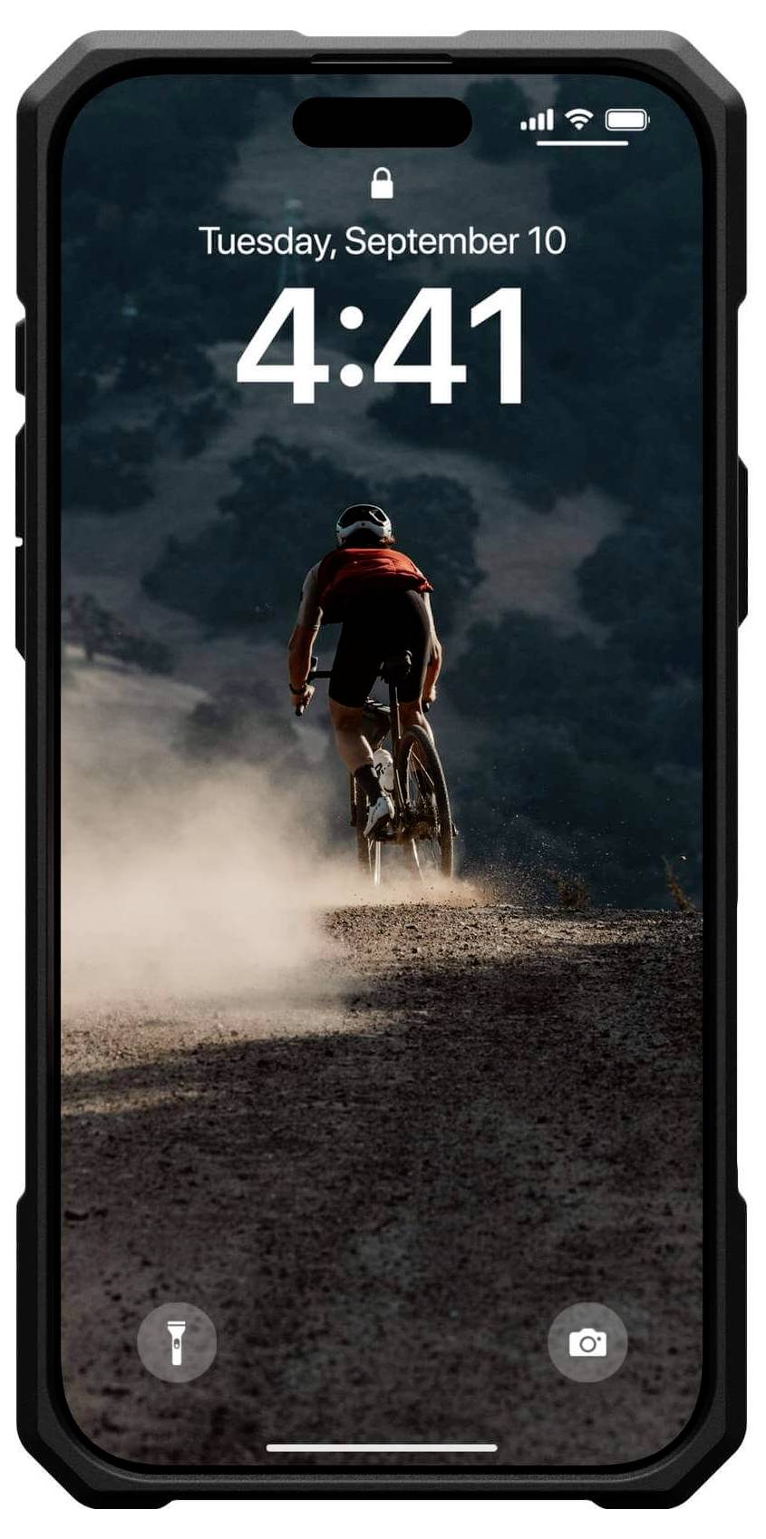 Ein Radfahrer fährt auf einem staubigen Weg bei Sonnenuntergang. Das Handy zeigt das Datum, Dienstag, 10. September, und die Uhrzeit, 4:41.