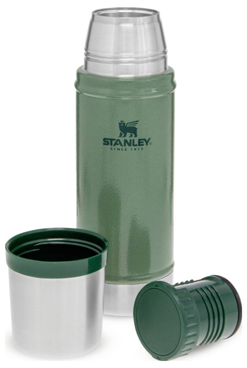 Grüne Thermoskanne mit Stanley-Logo, abgenommenem Deckel und kleinem Trinkbecher, isoliert gegen eine weiße Hintergrund.