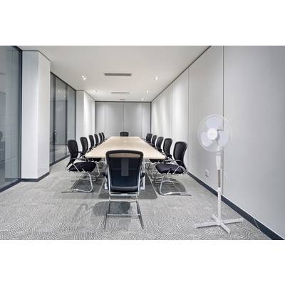 Moderner Konferenzraum mit langem Holztisch, umgeben von schwarzen Bürostühlen. An der Wand steht ein weißer Standventilator.