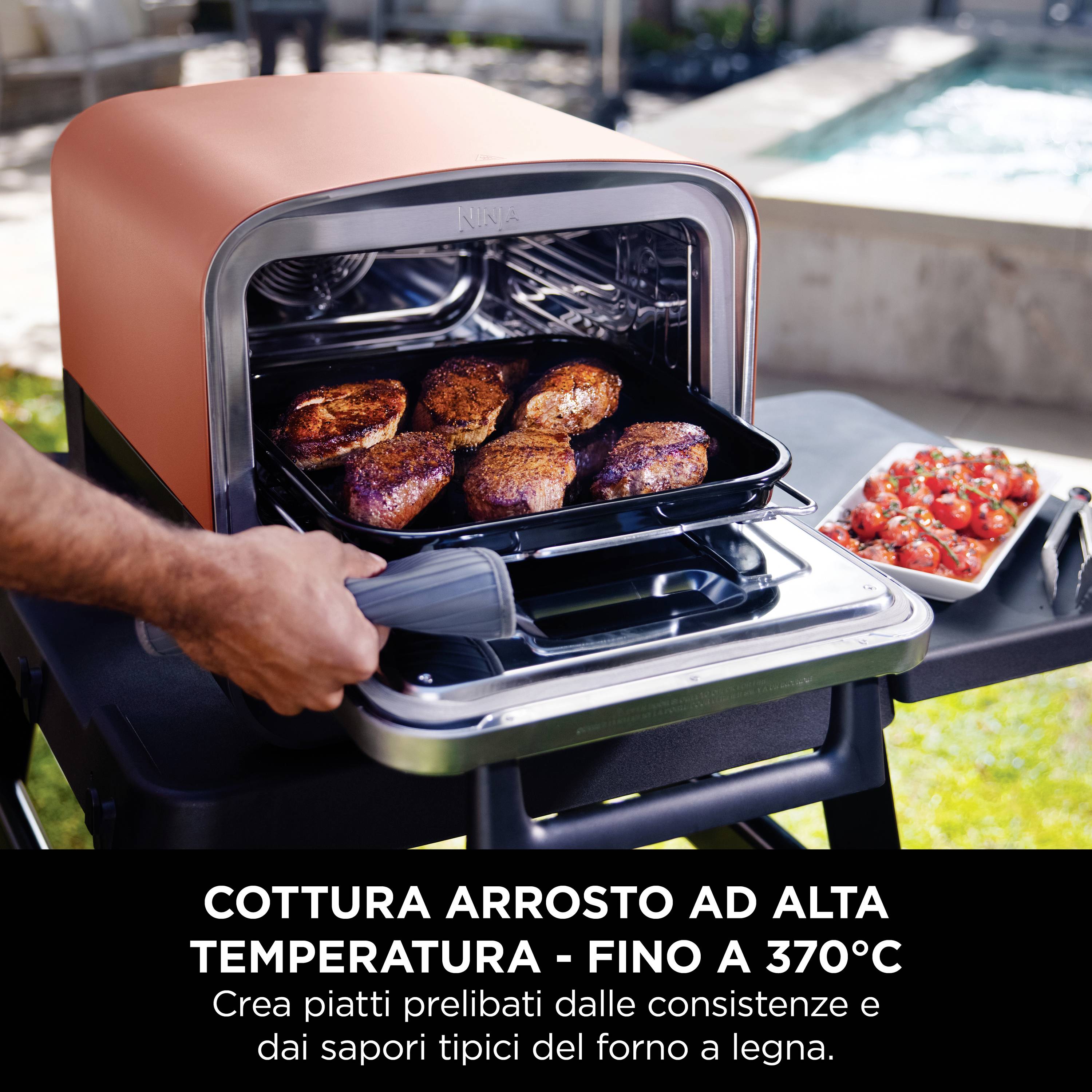 Ein Ofen wird geöffnet und zeigt sechs Stück Fleisch auf einem Blech. Daneben steht ein Tablett mit geschnittenen Tomaten. Text: 'Cottura arrosto ad alta temperatura - fino a 370°C'.