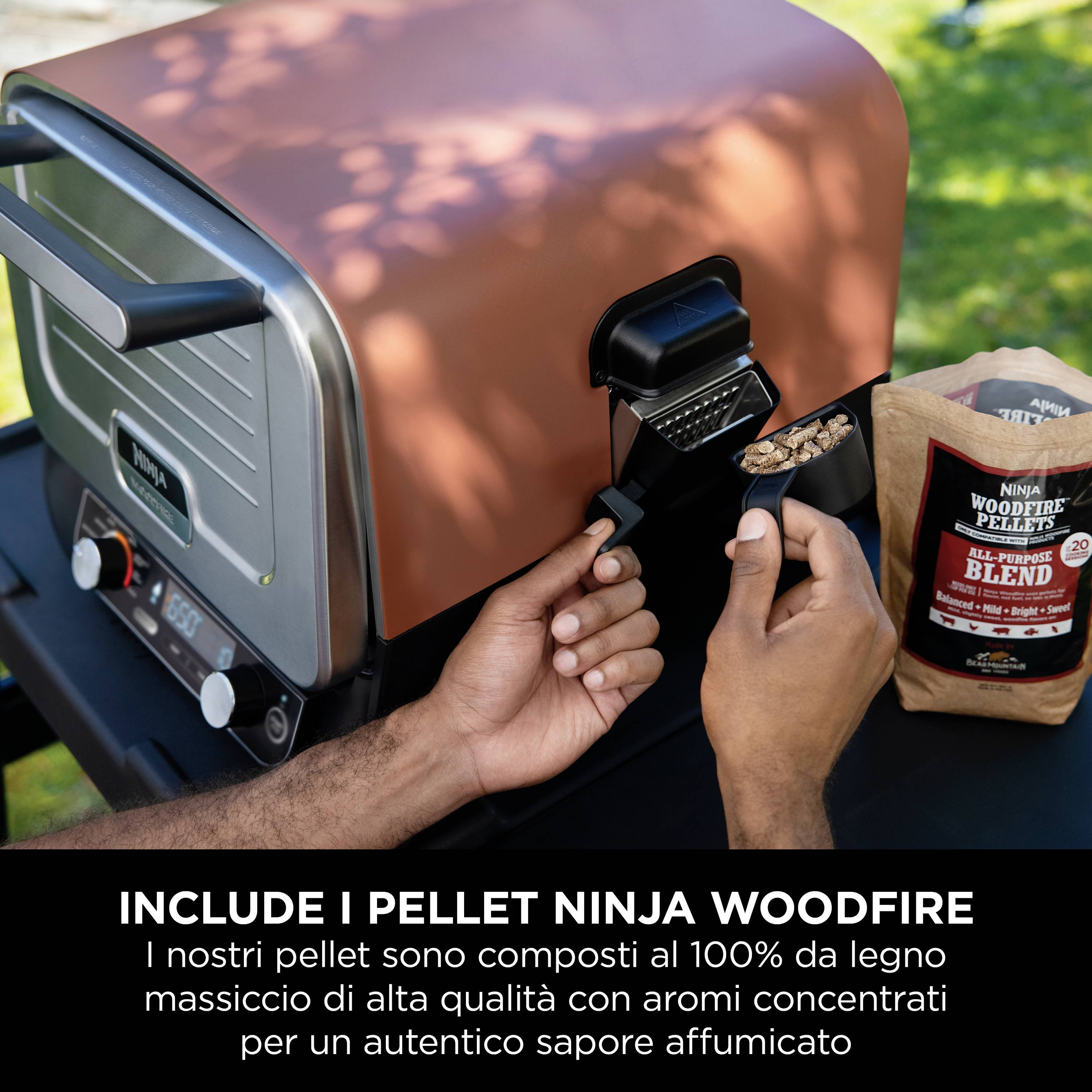 'Nahaufnahme eines Grills mit einer Hand, die Pellets einfüllt. Daneben steht eine Tüte mit der Aufschrift: NINJA Woodfire Pellets.'