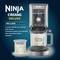 'Ninja Creami Deluxe' Eismaschine mit Zubehör. Beinhaltet Basis, Behälter mit Deckel, Rührpaddel und Rezeptbuch.