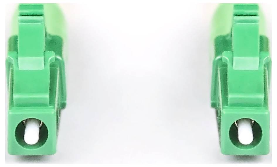 Zwei grüne Plastikklemmen liegen parallel zueinander auf einer weißen Oberfläche.