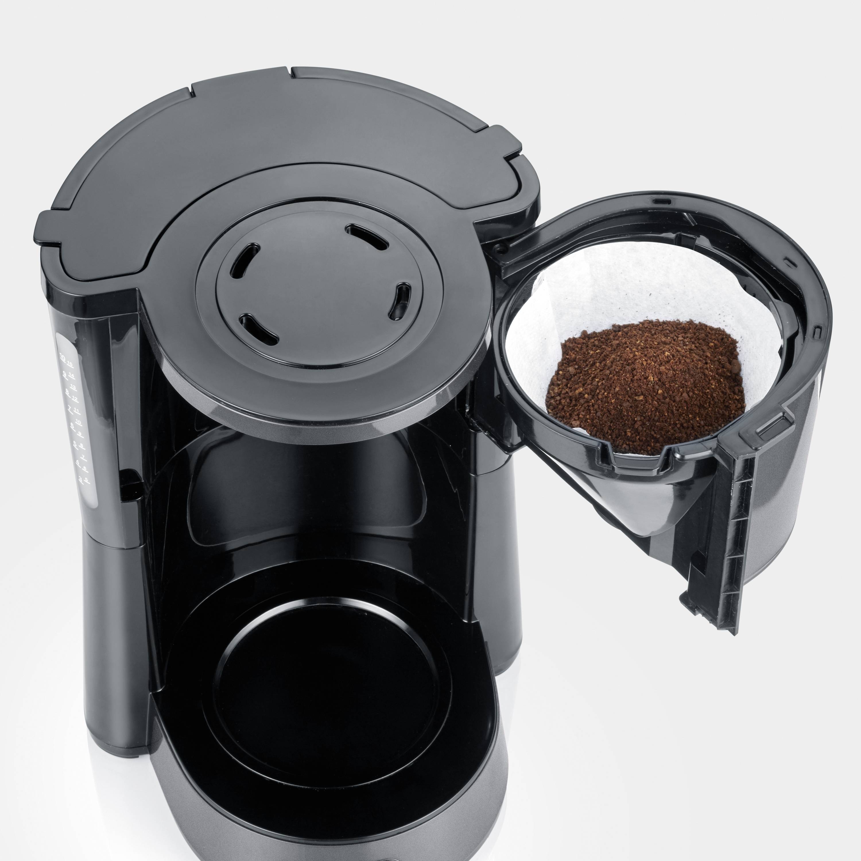 Kaffeemaschine mit geöffneter Kaffeefilterhalterung, gefüllt mit gemahlenem Kaffee. Zeigt den Aufbau und Funktionalität des Geräts.