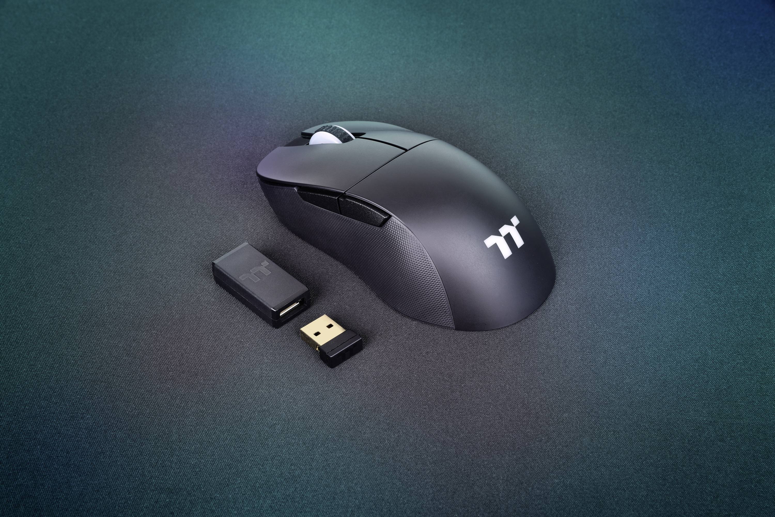 Schnurlose schwarze Computermaus mit USB-Empfänger auf schwarzem Hintergrund.