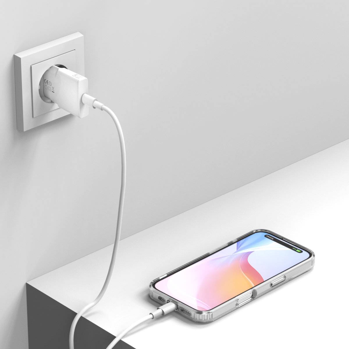 Ein Smartphone liegt auf einem Tisch und wird mit einem Ladegerät, das in eine Wandsteckdose eingesteckt ist, aufgeladen.