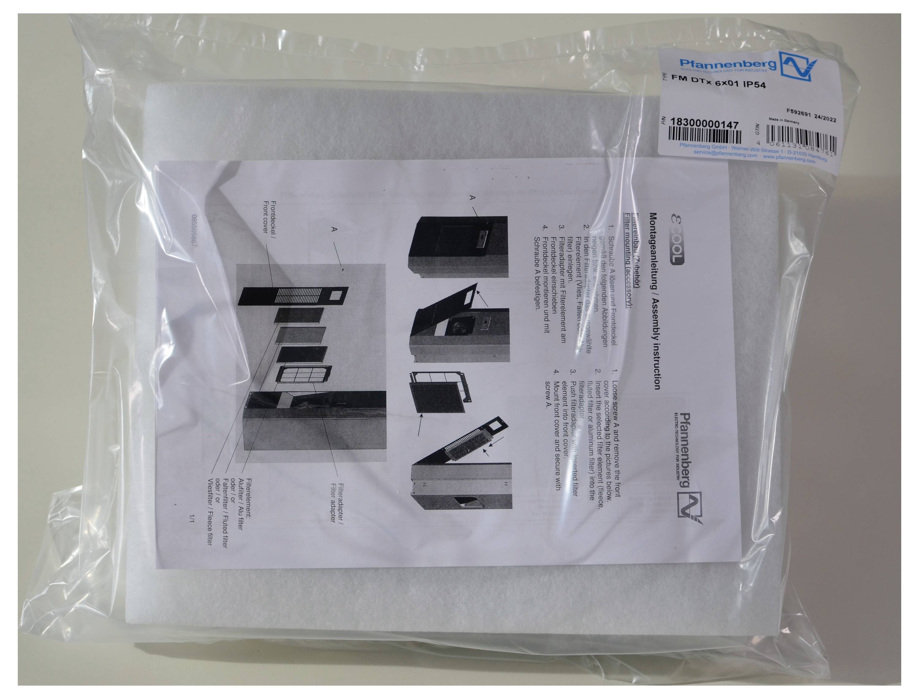 Eine verpackte Broschüre mit Anleitungen auf Englisch und einer Abbildung eines Gehäuseteils. Oben rechts ein Etikett mit Barcode.