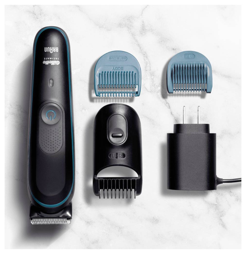 Ein Rasierapparat-Set mit einem elektrischen Trimmer, zwei blauen Kammaufsätzen und einem Ladegerät auf einer Marmoroberfläche.