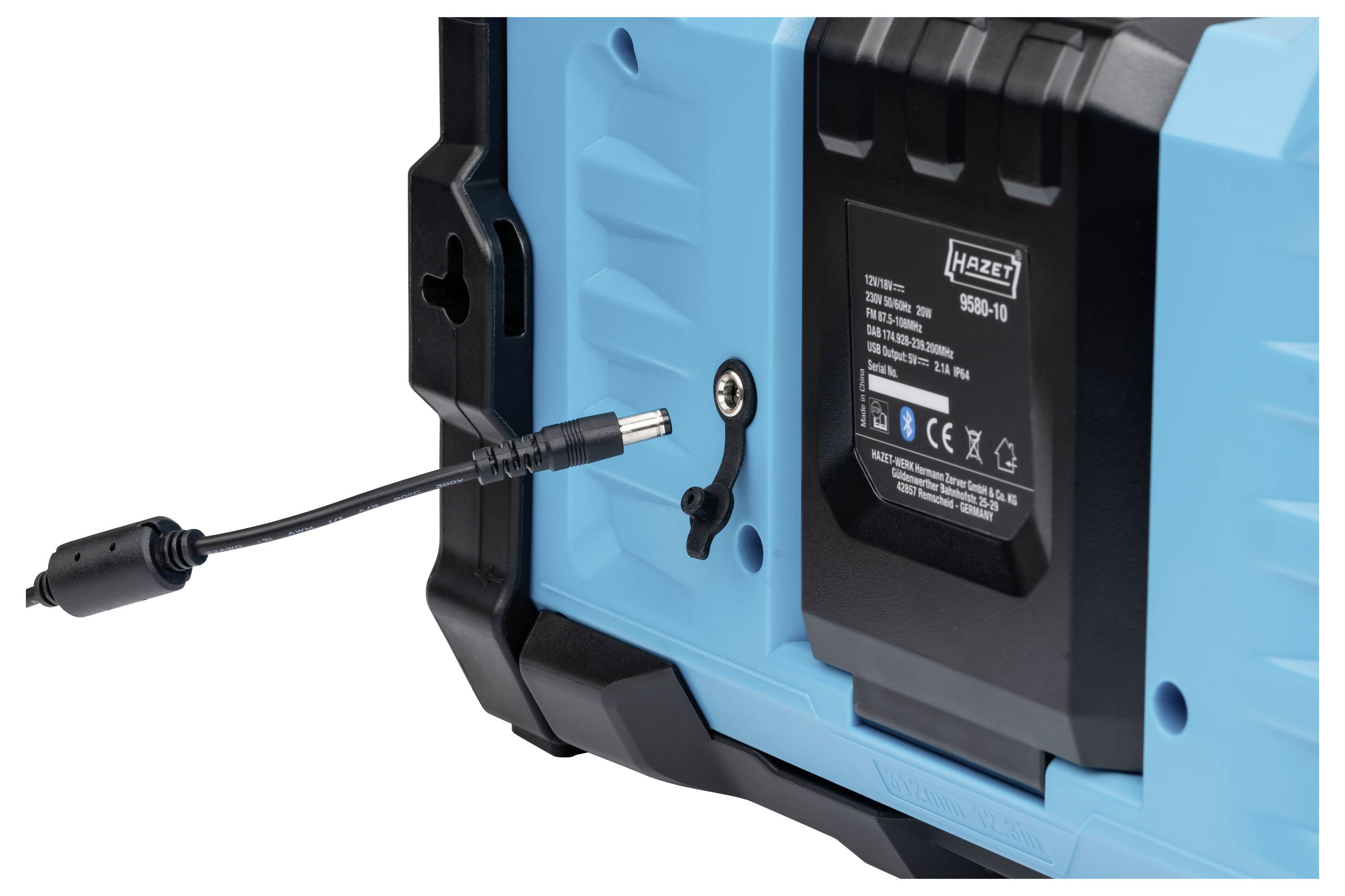 Nahaufnahme eines blauen tragbaren Batterie-Ladegeräts mit eingelegtem grauem Batteriepack und offenen schwarzen Fächern, die die Geräteoberfläche und Anzeigelichter zeigen.
