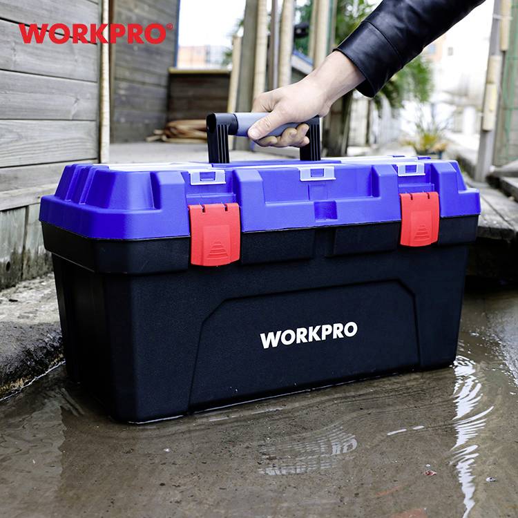 Eine Person hebt vorsichtig einen blauen und schwarzen Werkzeugkasten mit der Aufschrift 'WORKPRO' aus einer Pfütze.