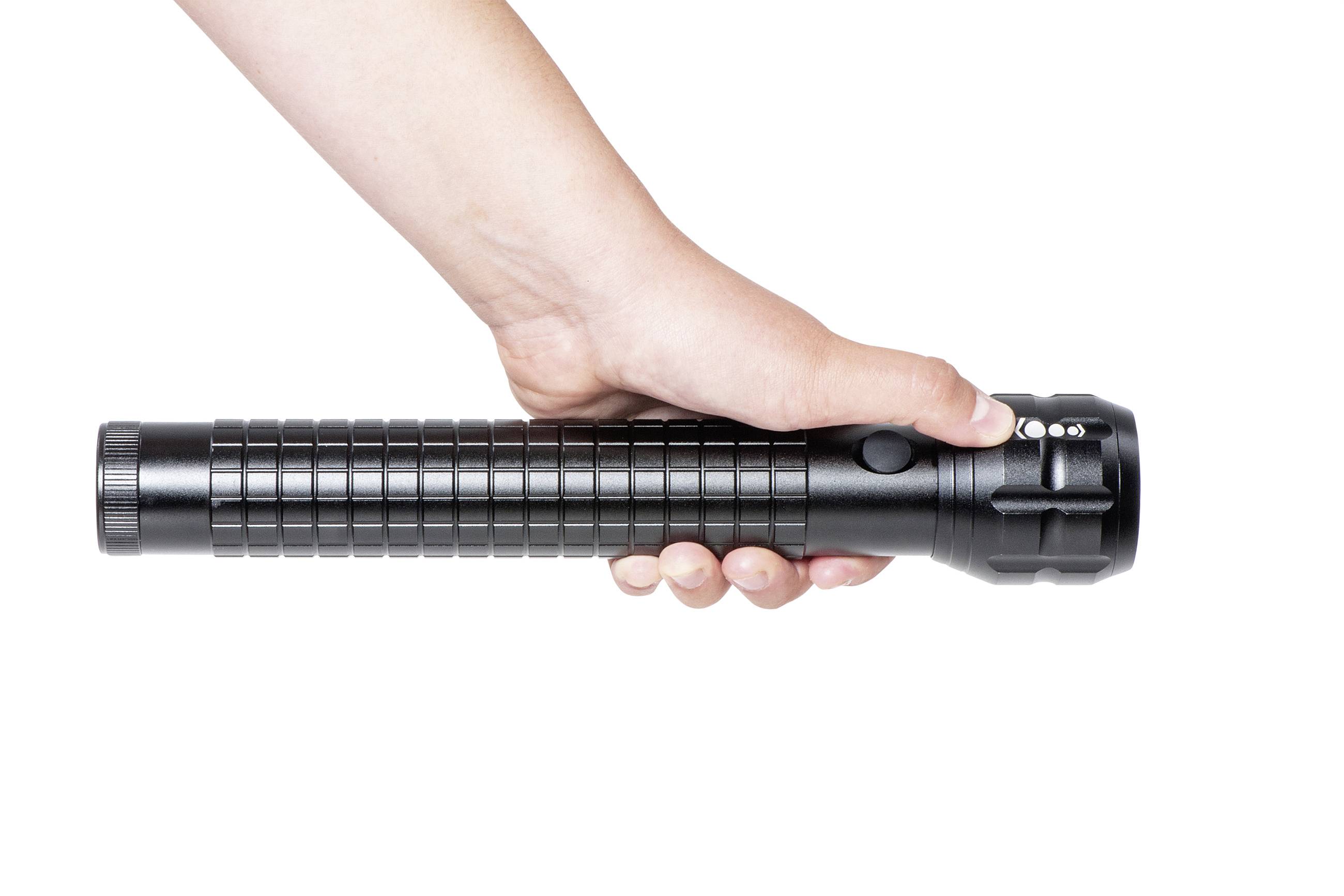 Eine Hand hält eine schwarze Taschenlampe mit geriffeltem Griff und seitlichem Knopf. Die Taschenlampe zeigt nach rechts.
