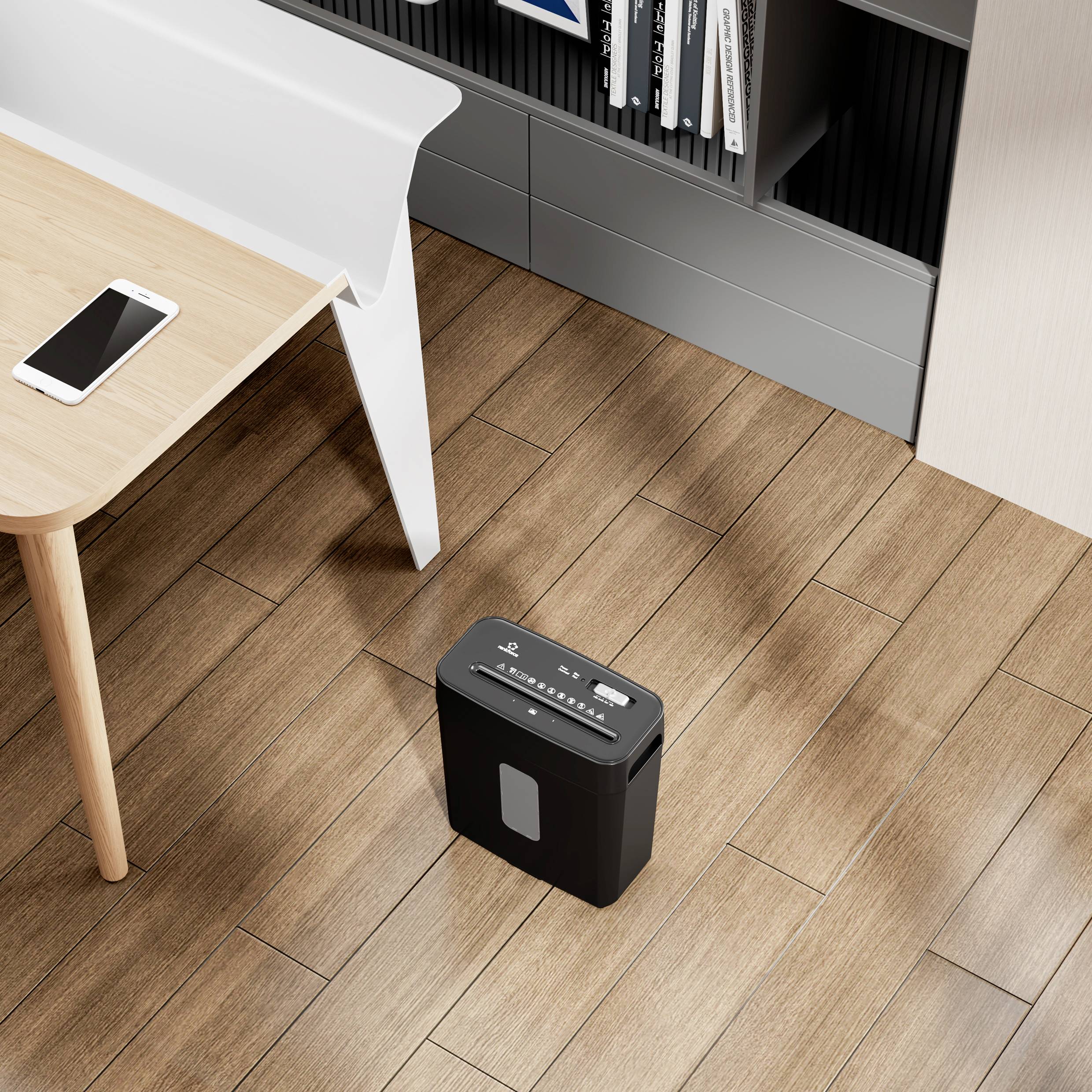 Bürosituation mit einem Holztisch, darauf ein Smartphone. Daneben ein Aktenvernichter auf Holzboden, im Hintergrund ein Regal.