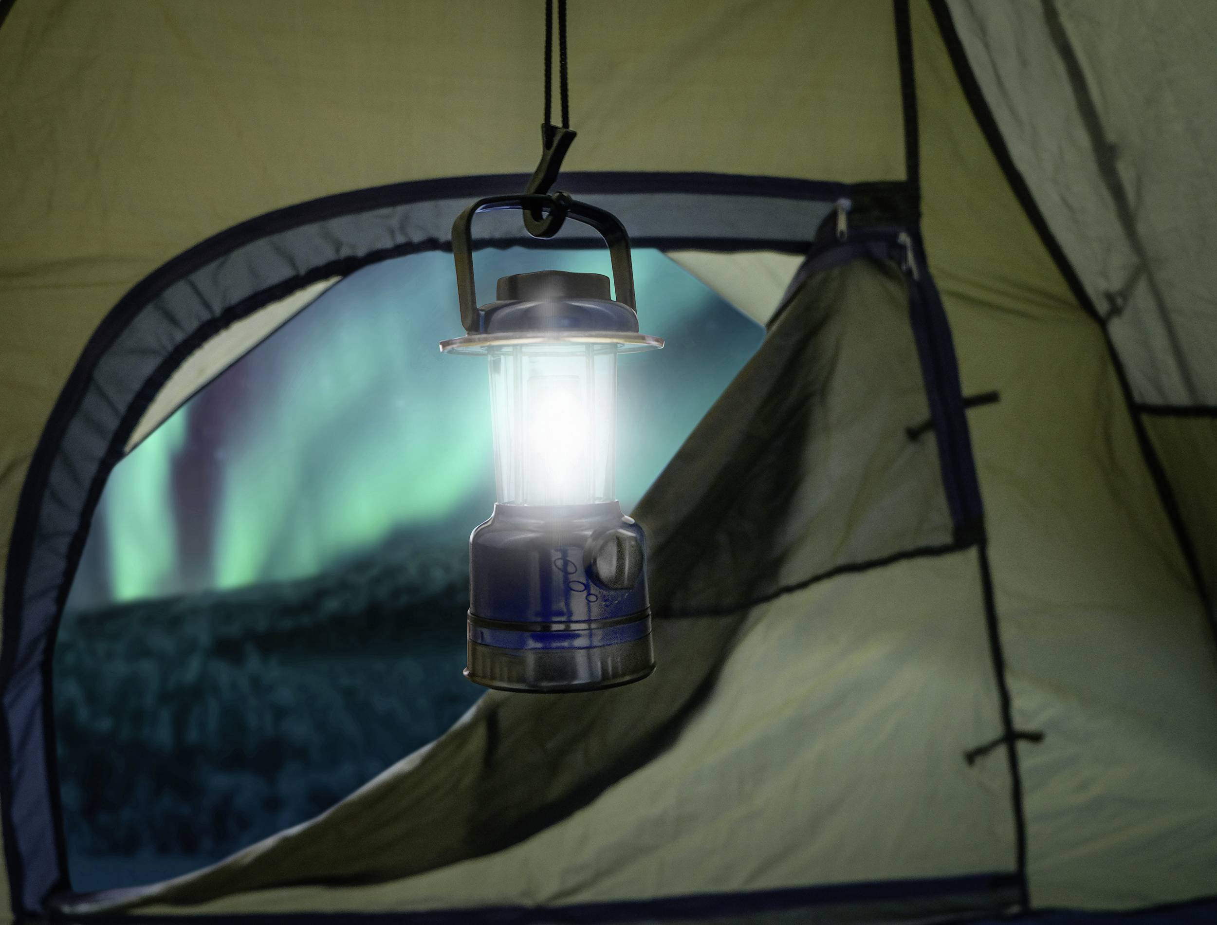 Ein Zelt mit einer hängenden Laterne im Vordergrund. Im Hintergrund sind Nordlichter zu sehen.