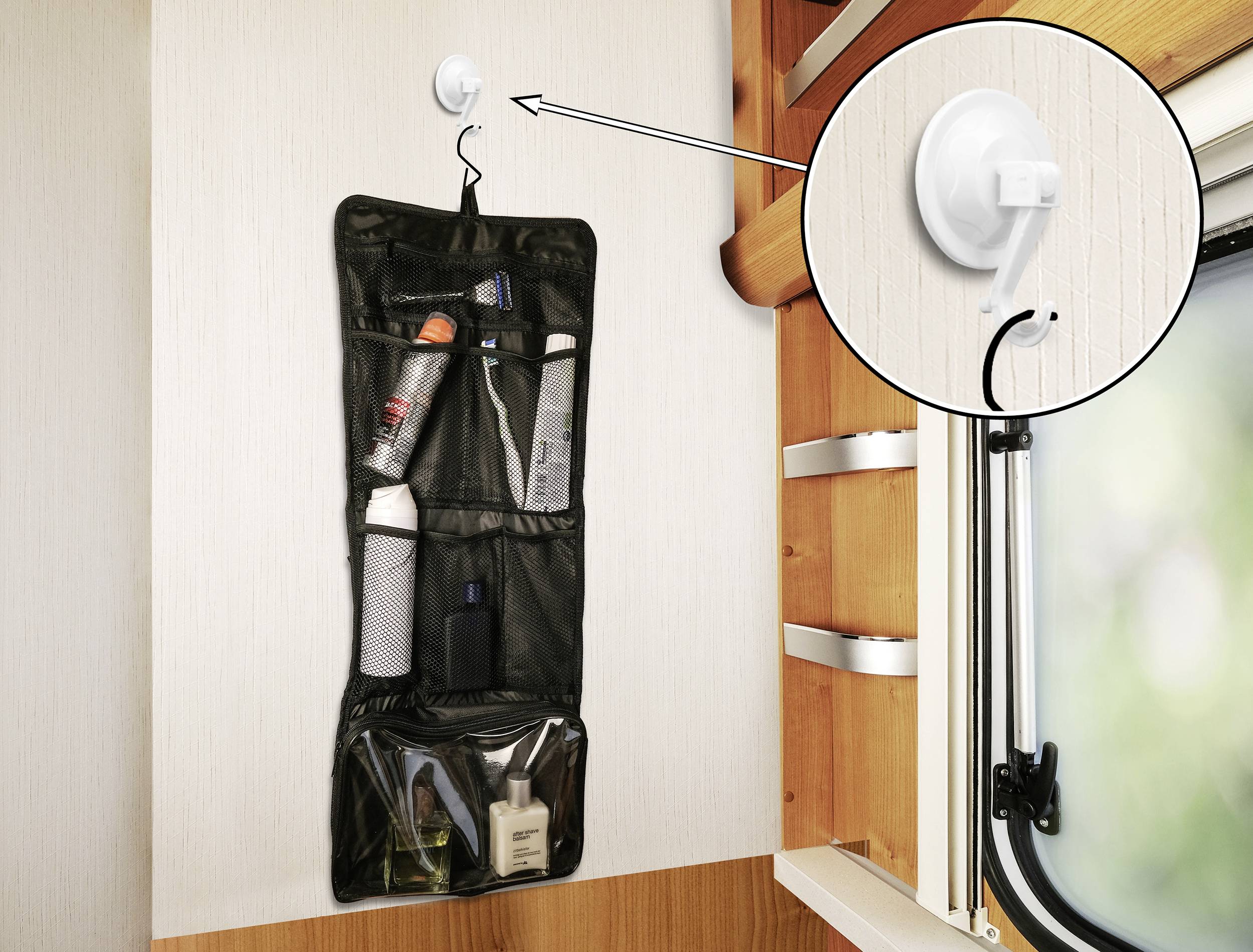 Schwarzer Organizer mit mehreren Fächern, hängt an einem Saugnapf an der Wand neben einem Fenster. Enthält Pflegeprodukte.