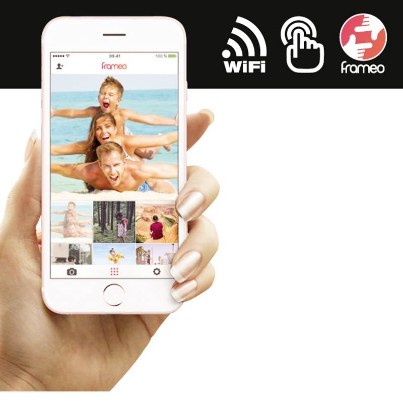 Eine Hand hält ein Smartphone mit einer Foto-App, die ein Bild von lächelnden Menschen im Wasser zeigt. Oben sind WLAN- und Logo-Symbole.
