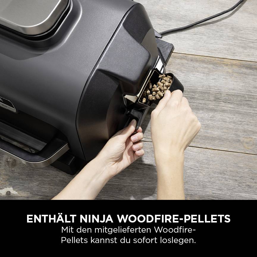 Eine Person füllt Pellets in einen Pelletgrill. Darunter steht: 'Enthält Ninja Woodfire-Pellets. Mit den mitgelieferten Woodfire-Pellets kannst du sofort loslegen.'