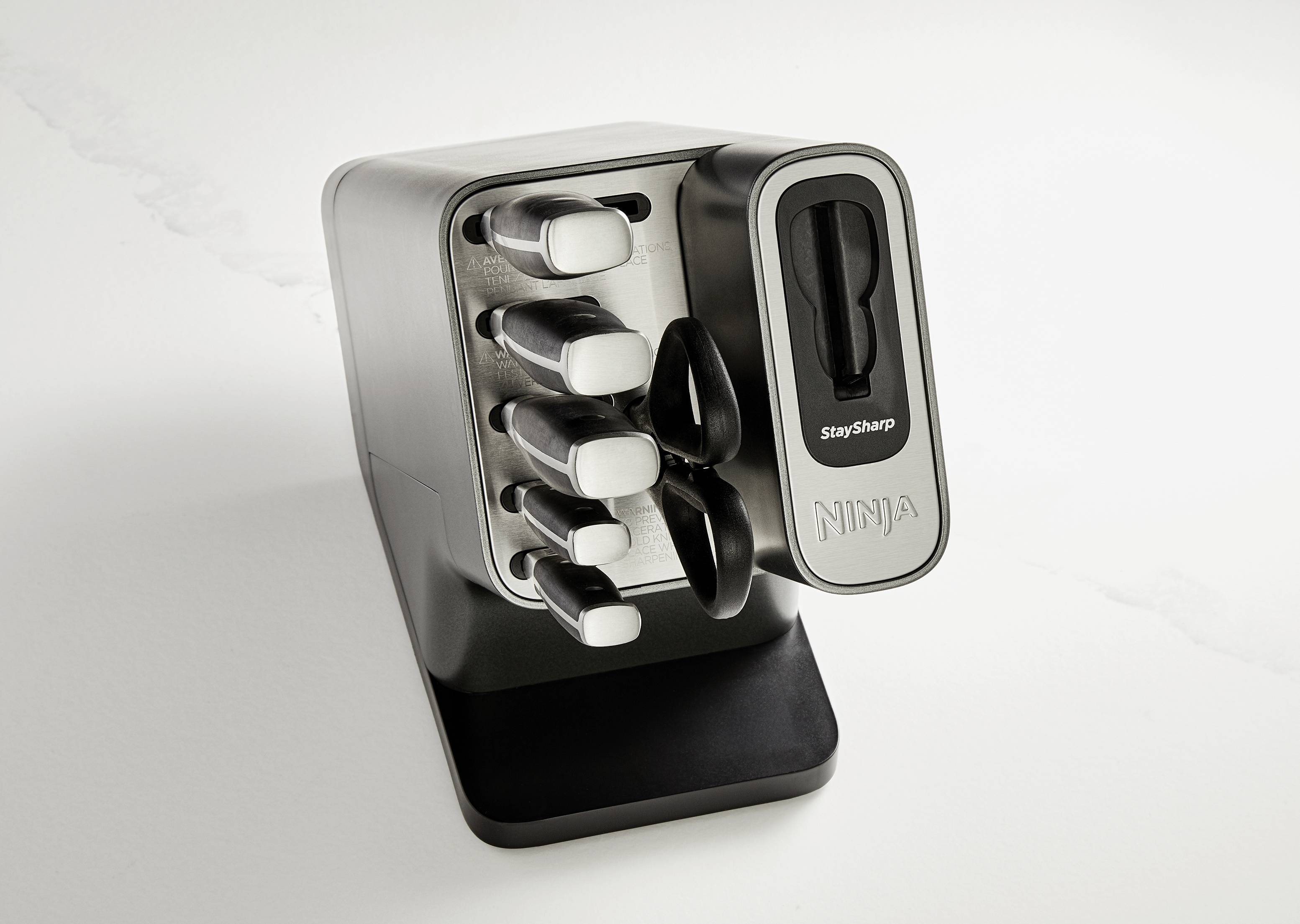 Ein Messerblock mit fünf Messern unterschiedlicher Größe. Das Design ist modern und die Messer sind im Block aufrecht angeordnet.