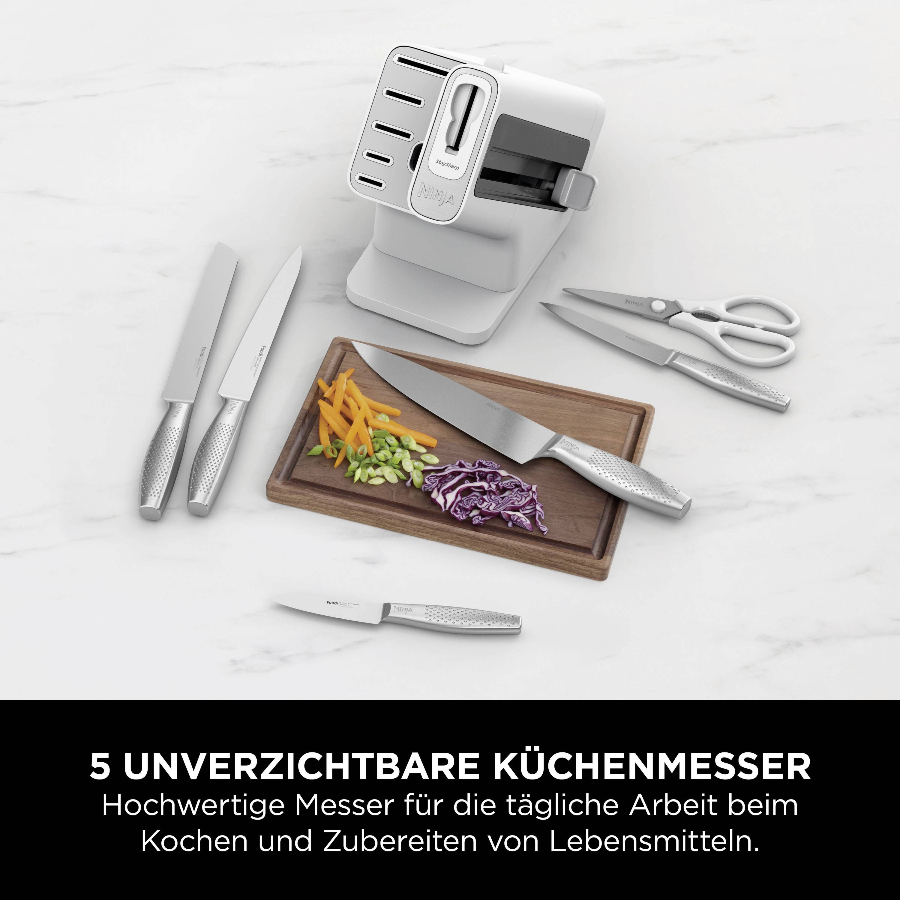 Ein Set von fünf Küchenmessern und einer Schere liegt neben einem Schneidebrett mit geschnittenem Gemüse. Text: '5 unverzichtbare Küchenmesser'.