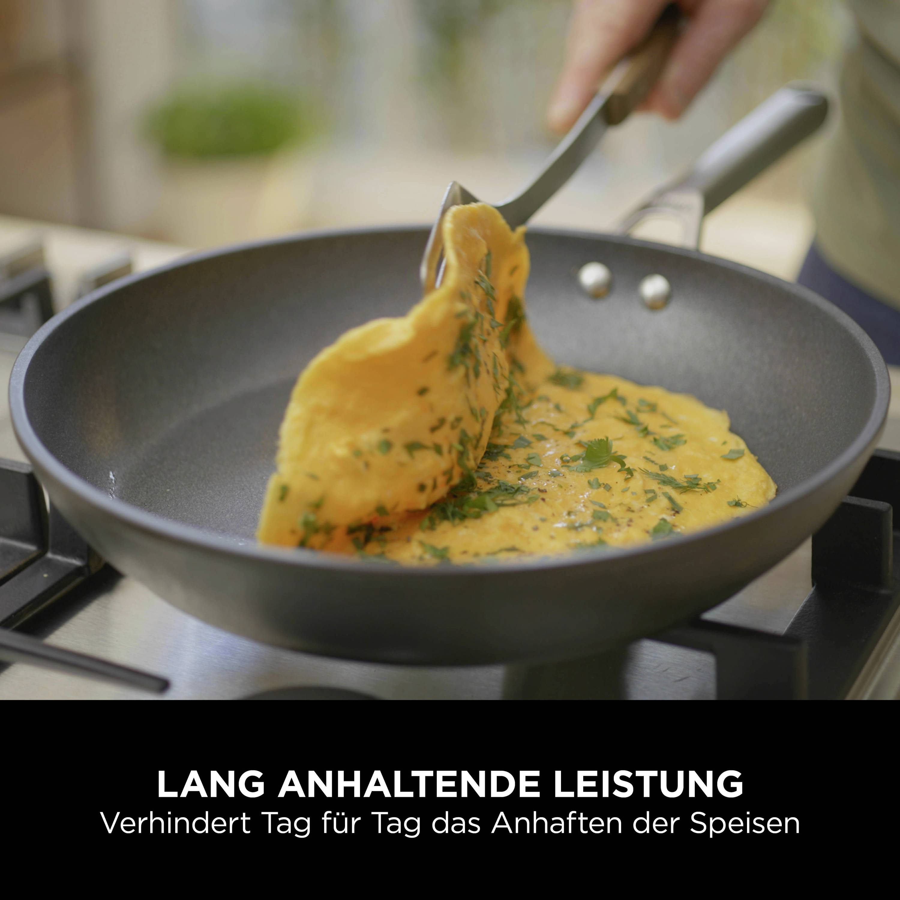 Eine Person brät ein Omelett in einer Pfanne. Text darunter: 'Lang anhaltende Leistung – Verhindert Tag für Tag das Anhaften der Speisen'.