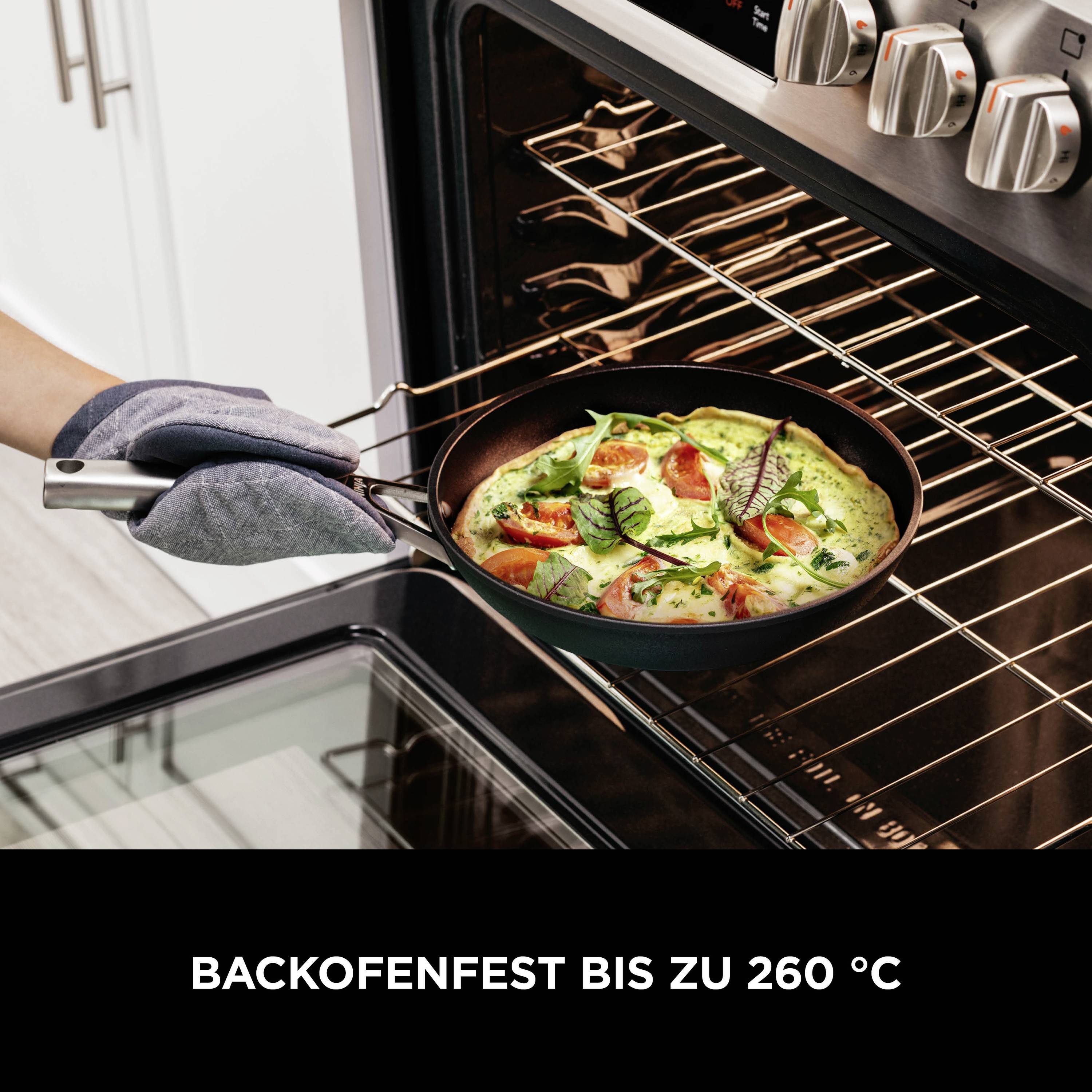 Ein Ofen wird geöffnet, während darin eine Pfanne mit grünem Gemüse und Tomaten unter dem Grillrost liegt. Text auf dem Bild: 'Backofenfest bis zu 260 °C'.