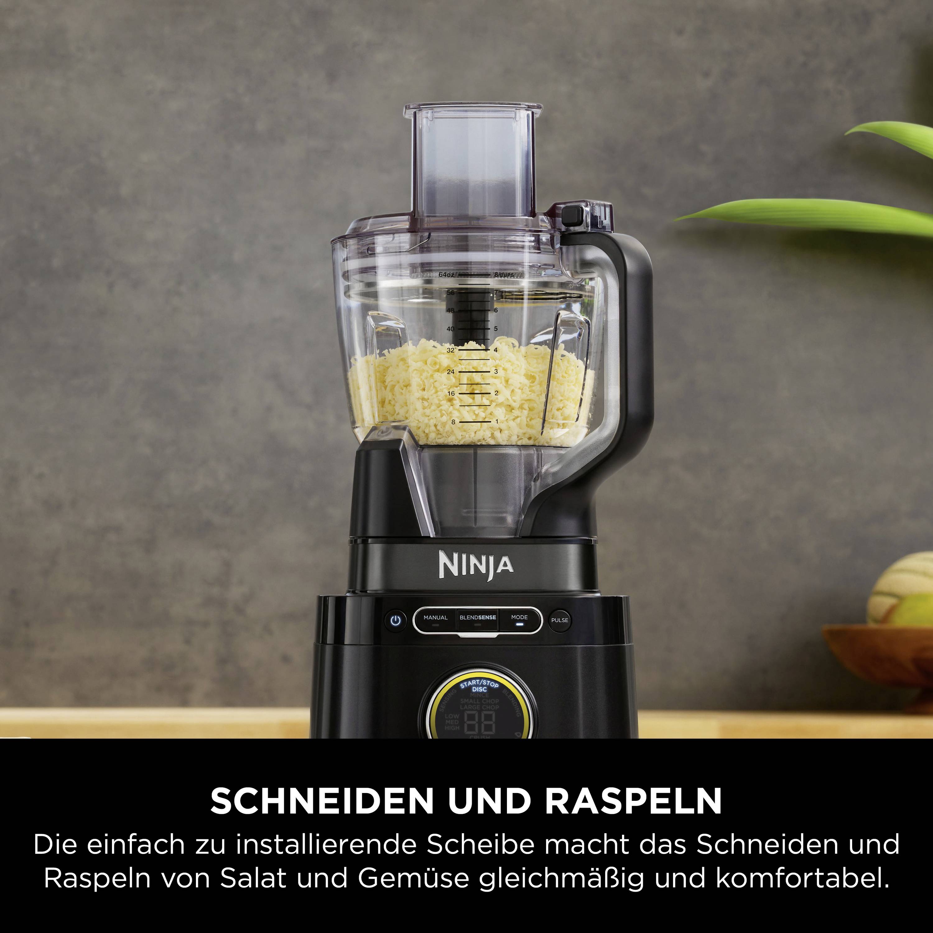 'Ninja'-Küchenmaschine mit Raspelscheibe, gefüllt mit geraspeltem Gemüse. Text erklärt die Funktion zum Schneiden und Raspeln.