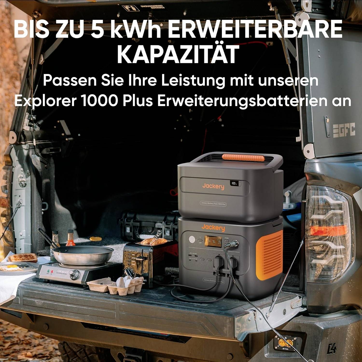 'Bis zu 5 kWh erweiterbare Kapazität' auf einem Autokofferraum mit tragbaren Batterien und anderem Campingzubehör.