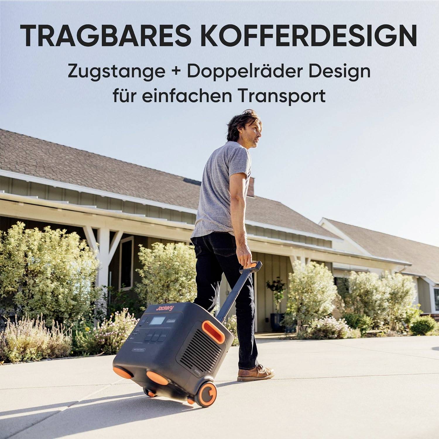 'TRAGBARES KOFFERDESIGN' Ein Mann zieht einen Koffer mit Zugstange und Doppelräder auf einer Straße. Haus im Hintergrund.