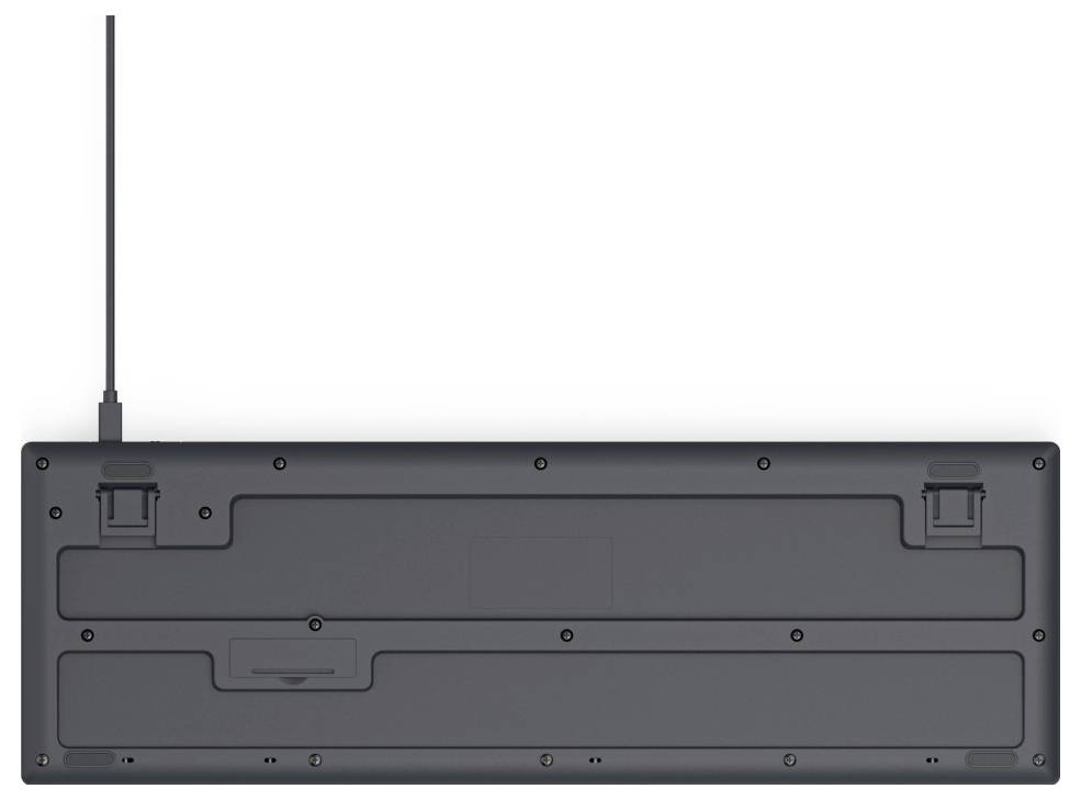 Rückseite einer schwarzen Computertastatur mit einem Kabelanschluss rechts oben und höhenverstellbaren Standfüßen.