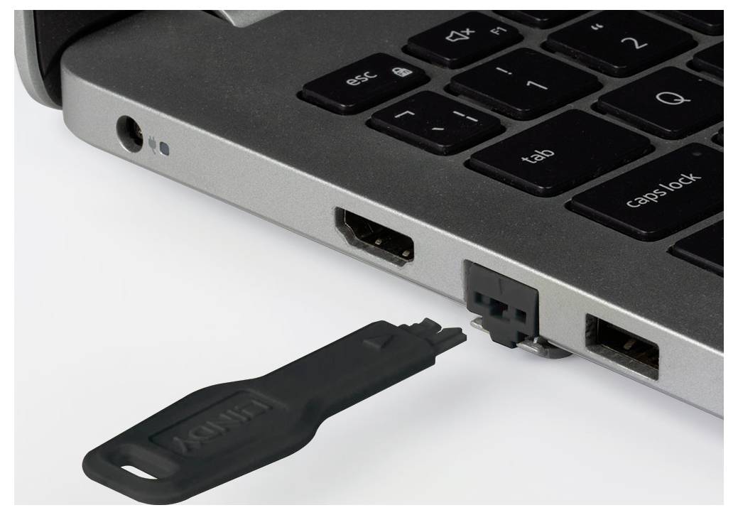 Nahaufnahme der Seitenports eines Laptops mit einem USB-Stecker, der in einen Port neben der Tastatur eingesteckt wird.