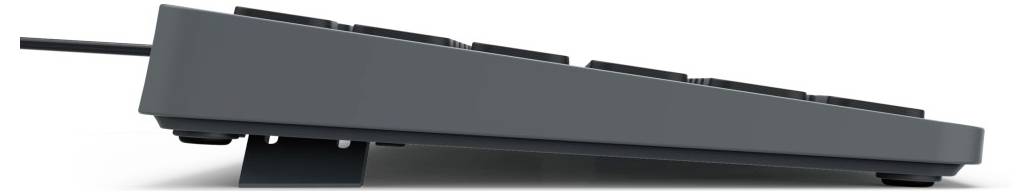 Seitenansicht einer schwarzen Computertastatur mit angewinkeltem Stand, die auf einer flachen Oberfläche liegt.