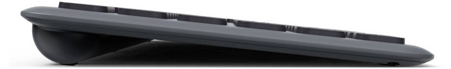 Schwarze computertastatur im Profil, leicht angewinkelt. Sie hat flache Tasten und eine abgerundete Unterseite für ergonomischen Komfort.