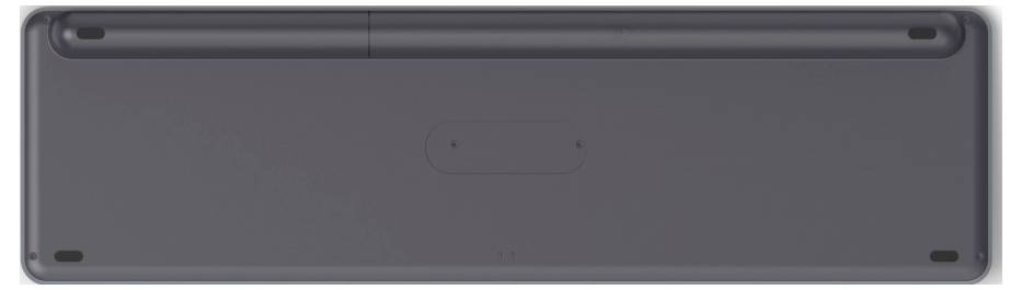 Rückseite einer schwarzen Tastatur, sichtbar sind Gummifüße an den Ecken und ein Fach in der Mitte, vermutlich für Batterien.