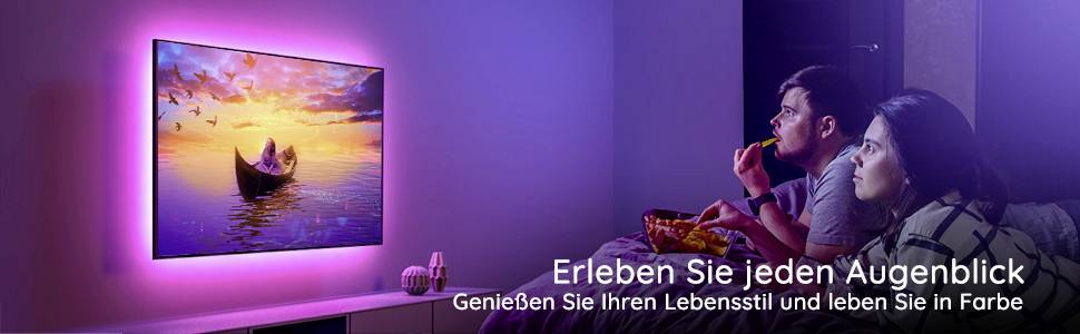 Ein Paar sitzt auf einem Sofa und schaut einen leuchtenden Fernseher mit Naturmotiv. Text: 'Erleben Sie jeden Augenblick'.