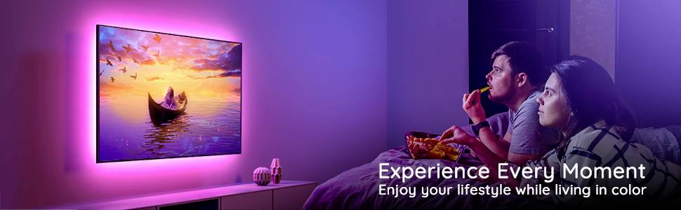 Ein Paar sitzt auf einem Sofa, isst Snacks und schaut auf einen bunt beleuchteten Fernseher. Text: 'Experience Every Moment' und 'Enjoy your lifestyle while living in color'.