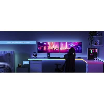 Gaming-Schreibtisch mit RGB-Beleuchtung, Monitor zeigt urbanes Neonmotiv. Sprachbedienung für Lichteinstellungen durch 'Alexa'.