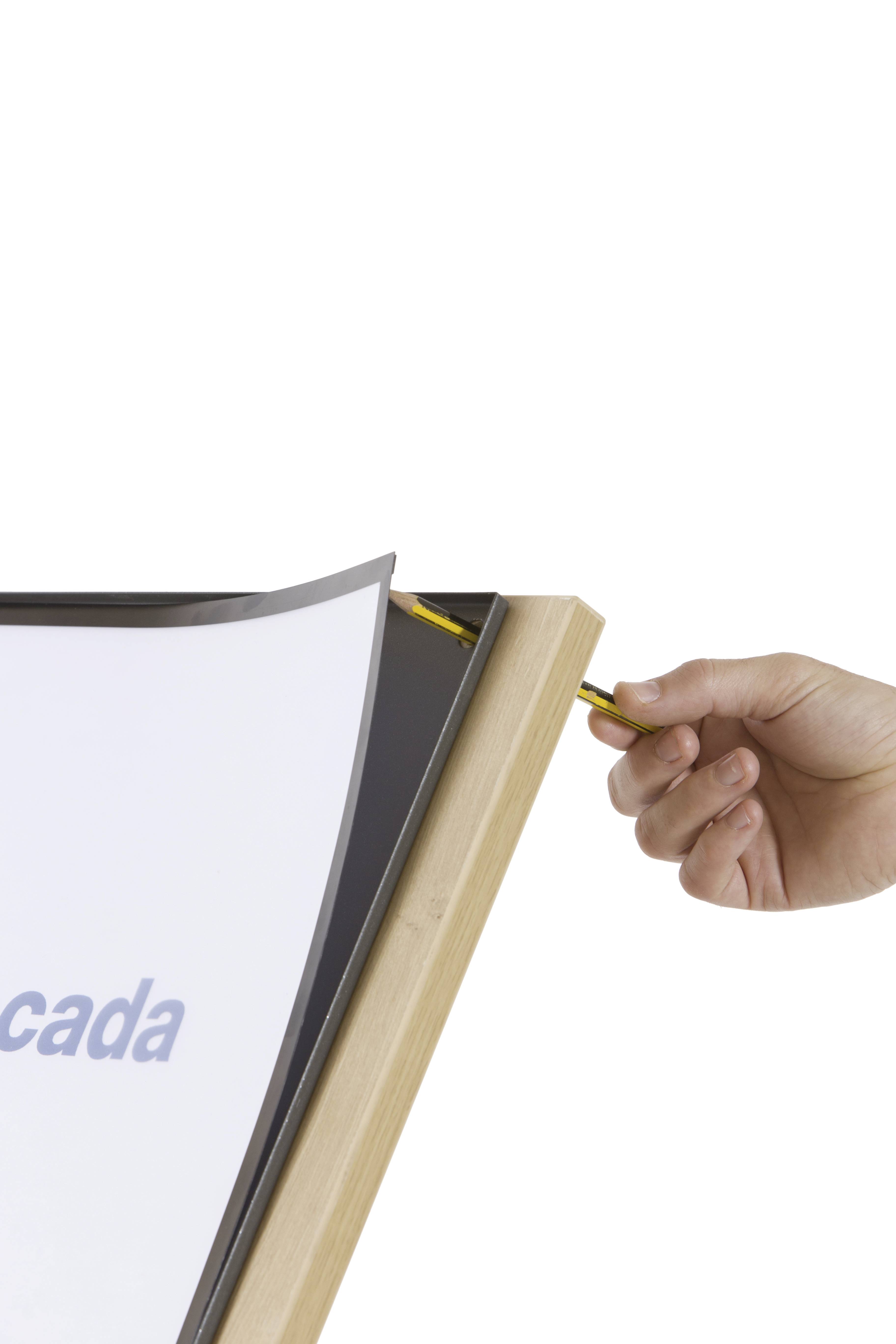 'Eine Hand legt einen Bleistift in eine Halterung eines Holzrahmens an einem Whiteboard.'